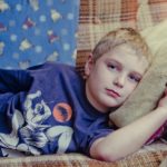 Boy lying on sofa